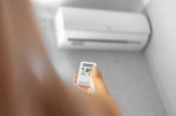 close-up-of-female-hand-adjusting-air-conditioner-with-remote-control_379201-2089